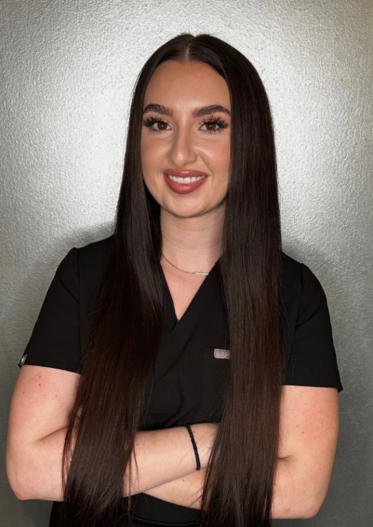 a woman with long hair wearing black scrubs